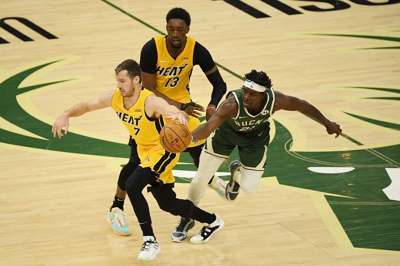 Jrue Holiday #21 knocks the basketball away from Goran Dragic #7