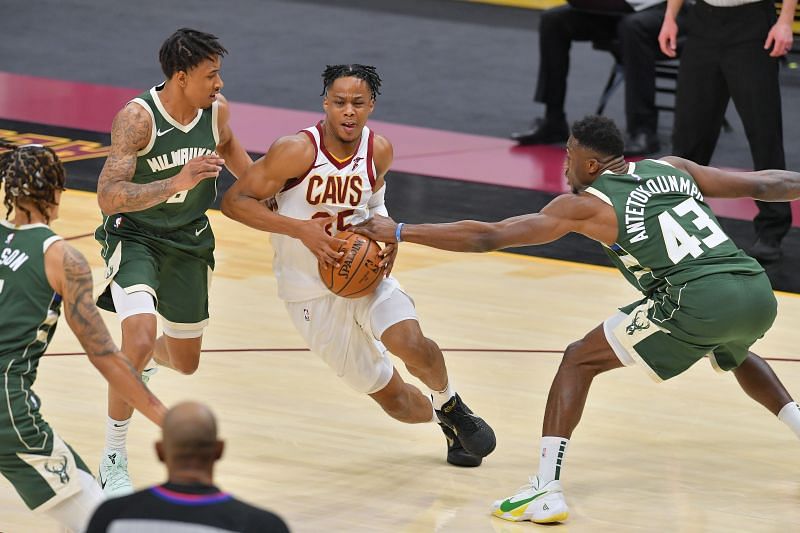 Isaac Okoro (#35) of the Cleveland Cavaliers drives against Jaylen Adams (#6) and Thanasis Antetokounmpo (#43) of the Milwaukee Bucks