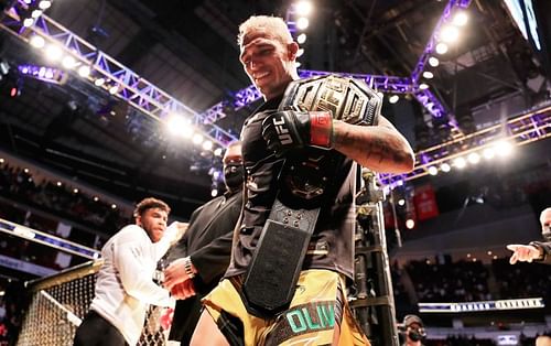 Charles Oliveira walks out of the octagon with the UFC lightweight belt on his shoulder