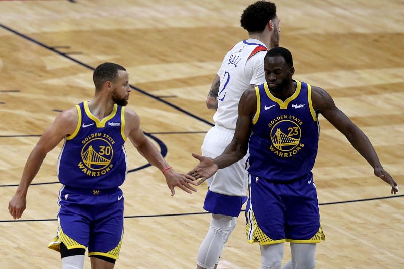 Stephen Curry #30 reacts with Draymond Green #23 after scoring a three-point basket.