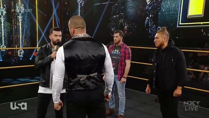 Karrion Kross being confronted by Finn Balor, Kyle O&#039;Reilly, and Pete Dunne