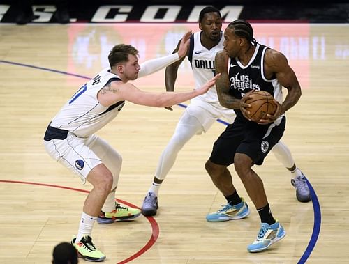 Kawhi Leonard is guarded by Luka Doncic and Dorian Finney-Smith