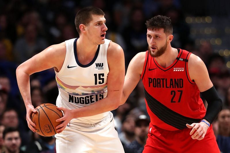 Nikola Jokic #15 of the Denver Nuggets is guarded by Jusuf Nurkic #27 of the Portland Trail Blazers