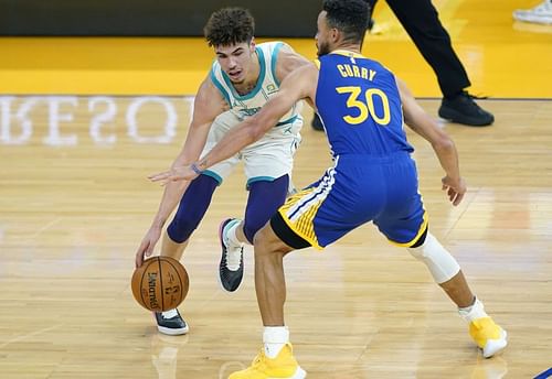 LaMelo Ball #2 looks to dribble past Stephen Curry #30