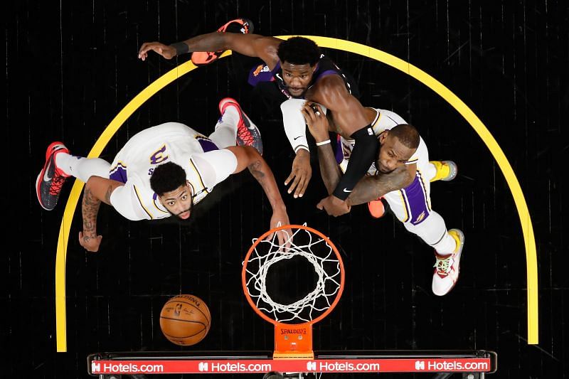 Anthony Davis and LeBron James block out Deandre Ayton.