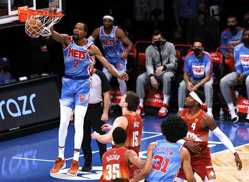 Kevin Durant #7 of the Brooklyn Nets dunks as Nikola Jokic #15 of the Denver Nuggets look on