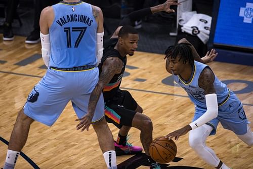 Ja Morant (#12) drives to the basket as Jonas Valanciunas (#17) sets the pick against Dejounte Murray (#5).