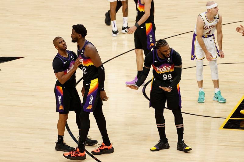 Deandre Ayton #22 is helped up by Chris Paul #3 during the second half.