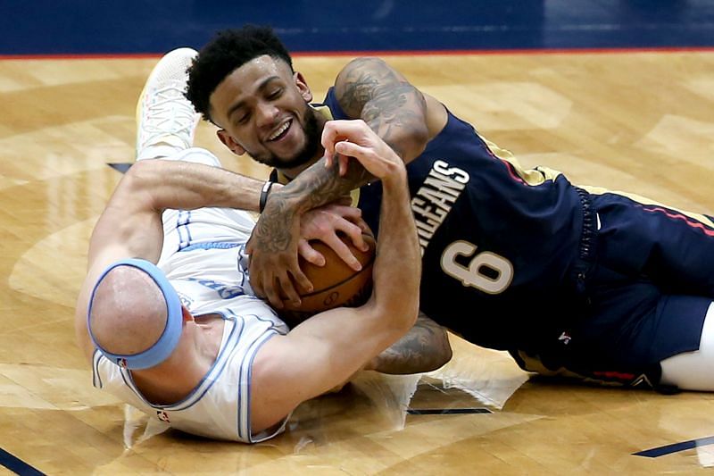 Nickeil Alexander-Walker #6 and Alex Caruso #4 battle for the loose ball.