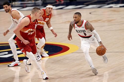 Damian Lillard #0 of the Portland Trail Blazers drives against Nikola Jokic.