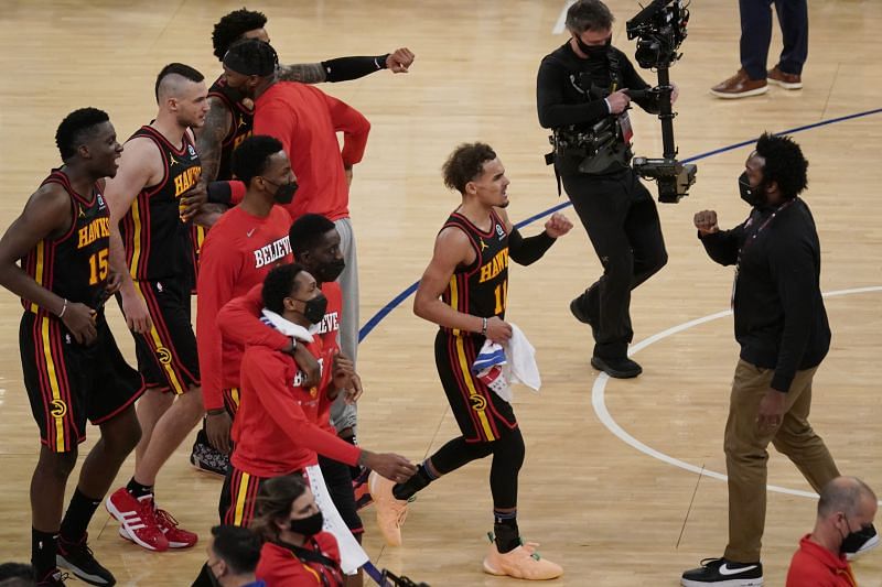 Trae Young (11), center, and the rest of the team celebrate after the Game 1 win over the New York Knicks