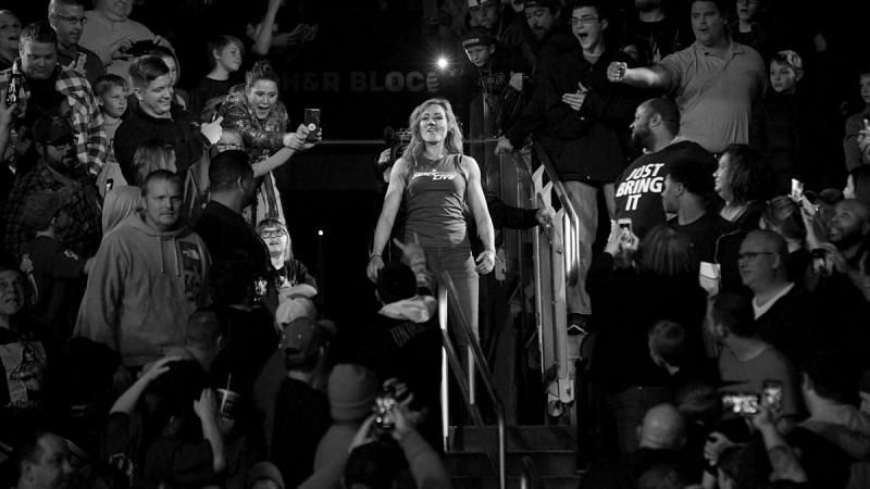 Becky Lynch stands amidst the crowd