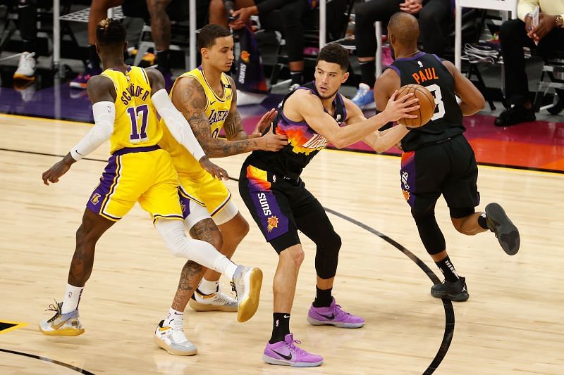 Devin Booker (#1) looks to pass against Kyle Kuzma (#0).