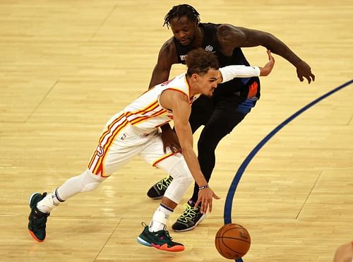 Trae Young #11 drives past Julius Randle #30.