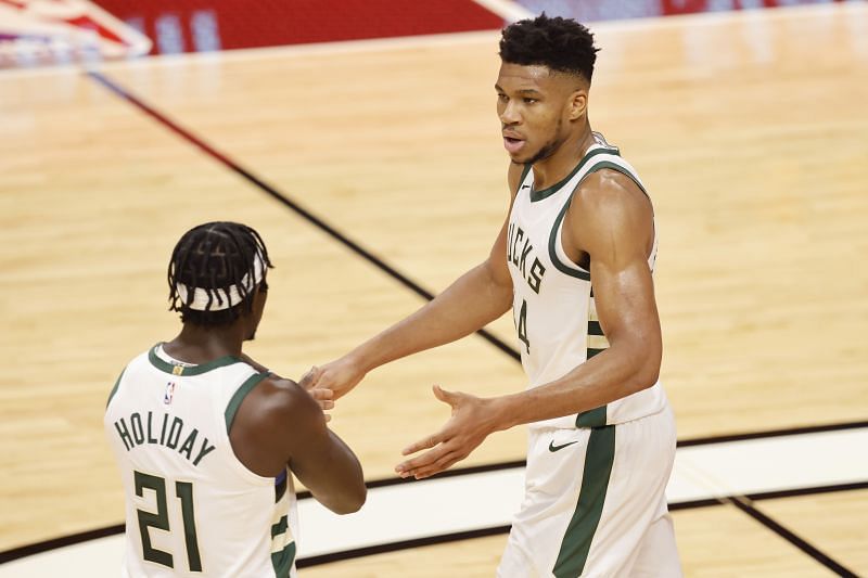 Giannis Antetokounmpo #34 of the Milwaukee Bucks high fives Jrue Holiday.