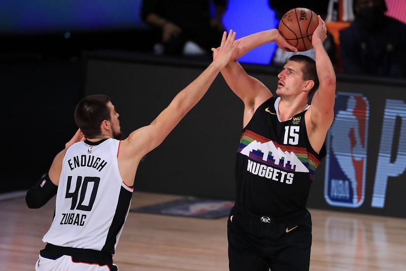 Nikola Jokic #15, attempts a jump shot over Ivica Zubac