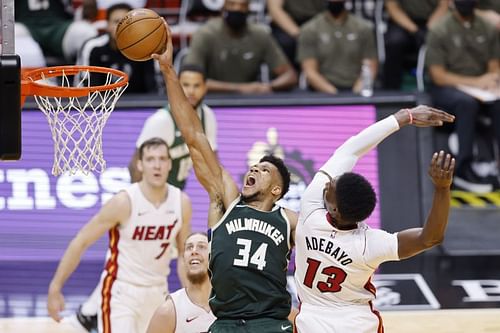 Giannis Antetokounmpo #34 of the Milwaukee Bucks dunks around Bam Adebayo #13 of the Miami Heat.