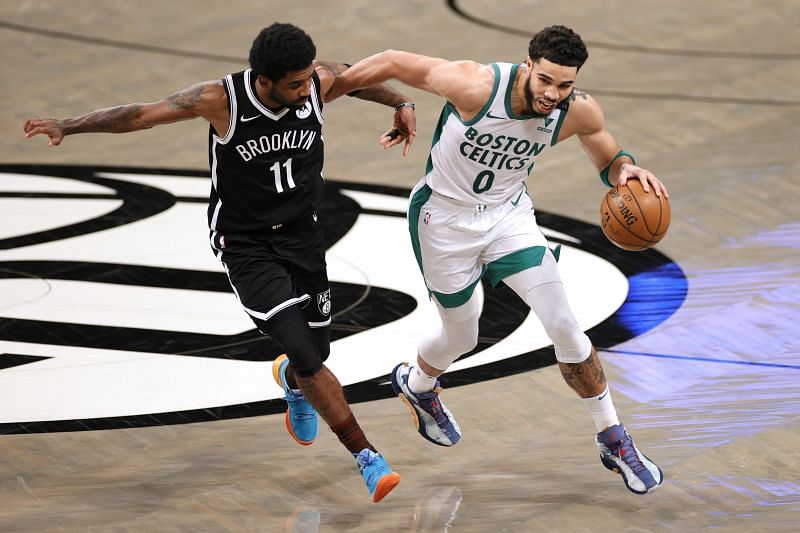 Jayson Tatum #0 of the Boston Celtics dribbles as Kyrie Irving #11 of the Brooklyn Nets