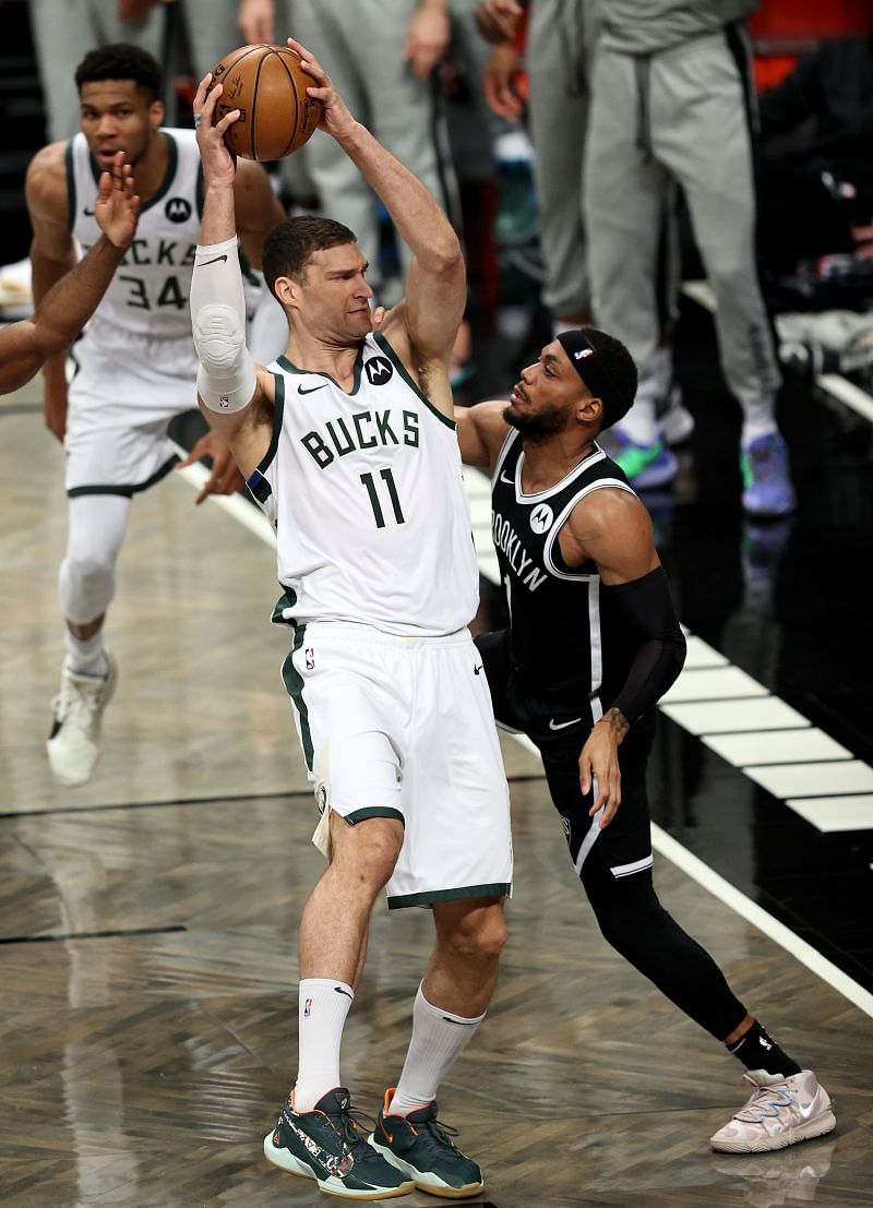 Brook Lopez (11) of the Milwaukee Bucks grabs a rebound of Bruce Brown (#1) of the Brooklyn Nets.