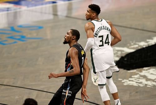 The Brooklyn Nets' Kevin Durant #7 watches his shot as the Milwaukee Bucks' Giannis Antetokounmpo #34 looks on