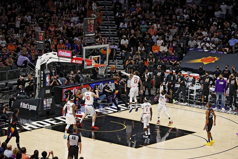 Deandre Ayton (#22) of the Phoenix Suns drives to the rim ahead of Paul George (#13) of the LA Clippers.