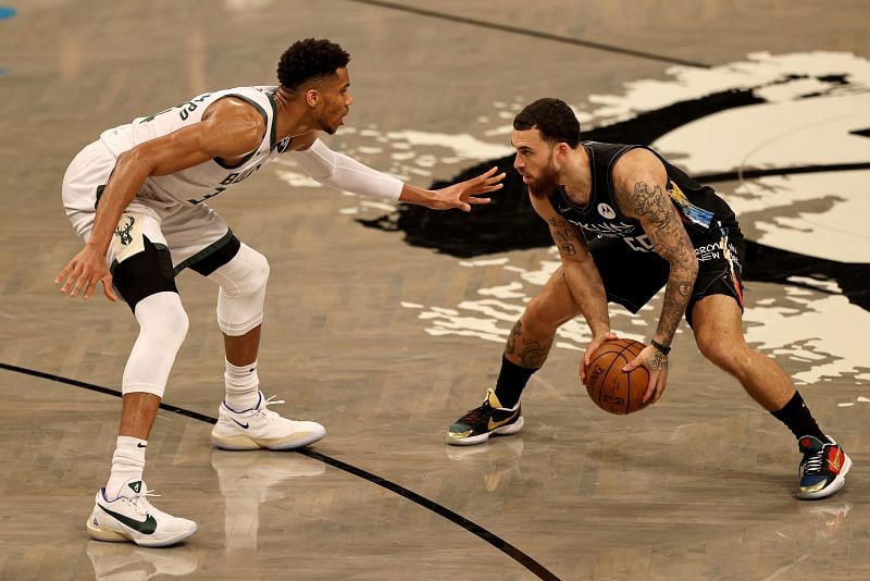 Giannis Antetokounmpo (#34) guards Mike James (#55).