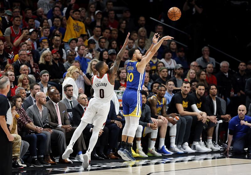 The Golden State Warriors&#039; Stephen Curry #30 shoots the ball against the Portland Trail Blazers&#039; Damian Lillard #0