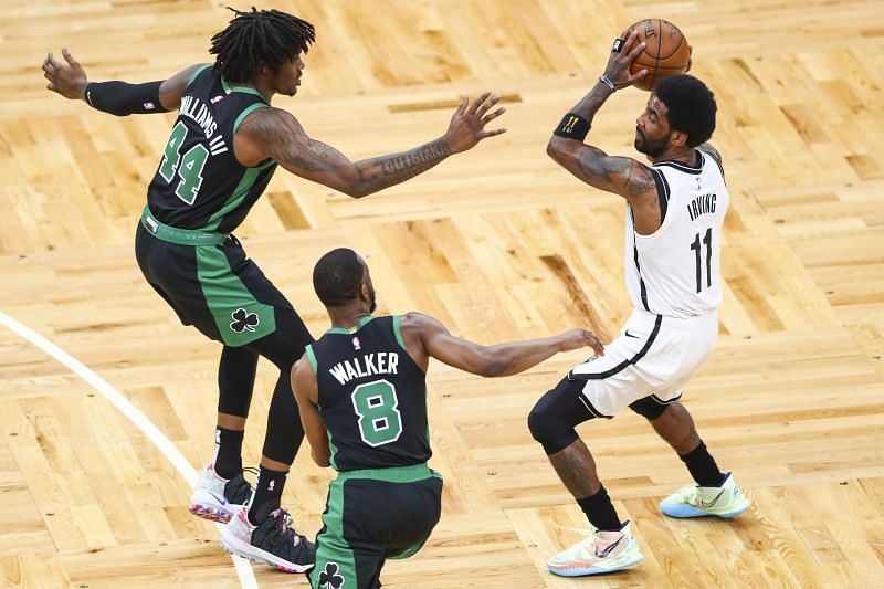 Kyrie Irving #11 of the Brooklyn Nets is double teamed by Robert Williams III and Kemba Walker #8 of the Boston Celtics