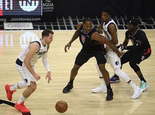 Luka Doncic uses a screen set by Josh Richardson on Kawhi Leonard.