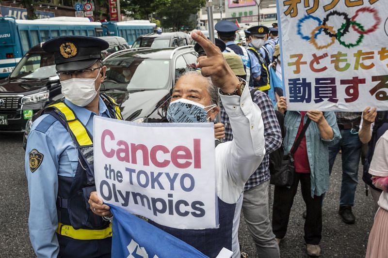 A protester holds a placard during a demonstration against the Tokyo Olympics