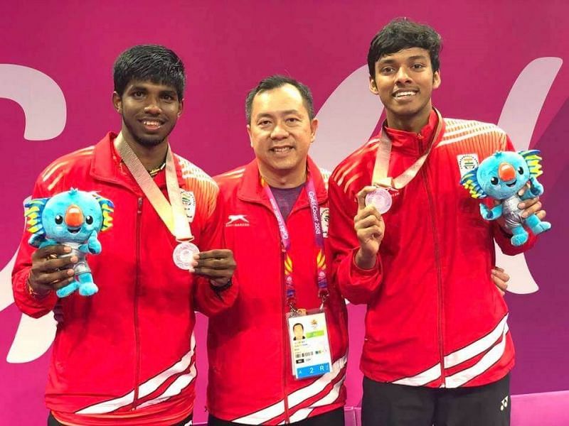 Tan Kim Her (center) with Chirag Shetty and Satwiksairaj Rankireddy (left)