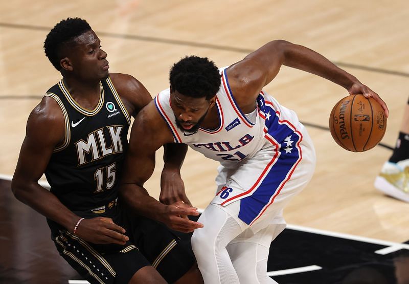 Clint Capela (#15) of the Atlanta Hawks draws an offensive foul as Joel Embiid (#21) of the Philadelphia 76ers drives into him.
