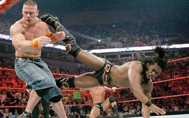 John Cena getting kicked by Kofi Kingston during a Triple Threat match