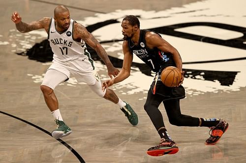 Kevin Durant (#7) drives past PJ Tucker (#17).