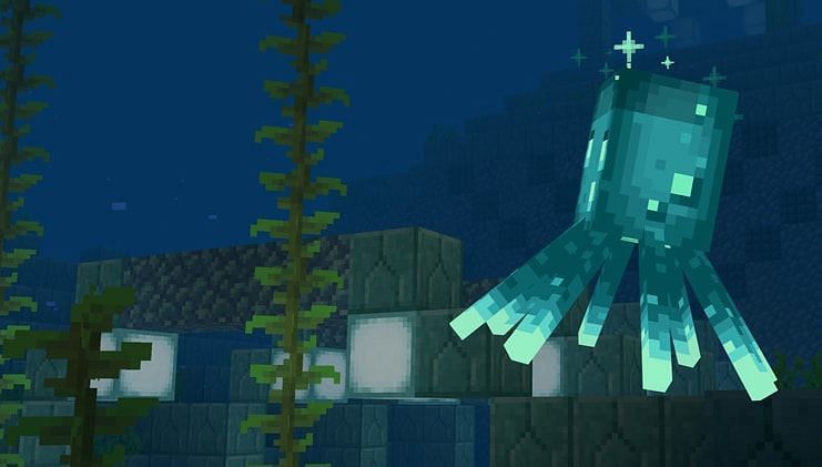 A glow squid swimming around an ocean monument (Image via Mojang)