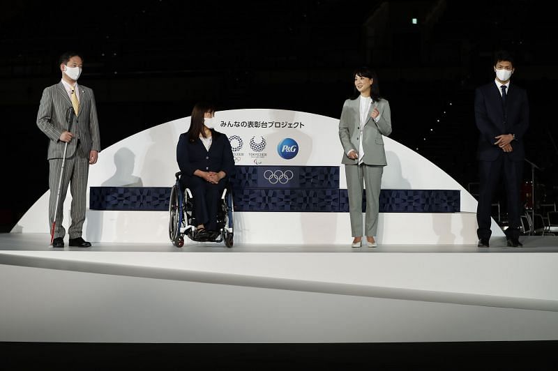Kyoko Iwasaki standing third from left at the unveling of Tokyo 2020 Victory Ceremony Podium, Costume, Music and Medal Tray