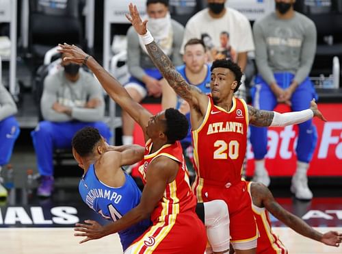 Giannis Antetokounmpo (#34) is pressured by Onyeka Okongwu (#17) and John Collins (#20).