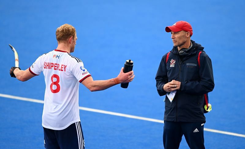 Great Britain head coach Danny Kerry (R) speaks to Rupert Shipperley during an FIH Pro League match