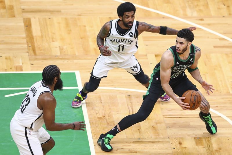 Jayson Tatum (#0) is guarded by Kyrie Irving (#11) and James Harden (#13).