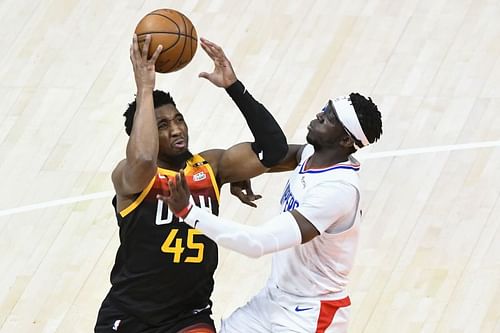 Donovan Mitchell is fouled by Reggie Jackson