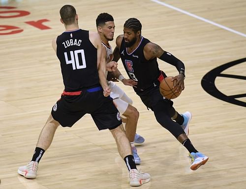 Paul George #13 of the Clippers uses the screen of Ivica Zubac #40 on Devin Booker #1 of the Suns