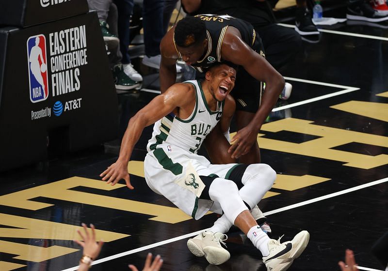 Giannis Antetokounmpo #34 of the Bucks reacts after an injury after landing awkwardly with Clint Capela #15 of the Hawks