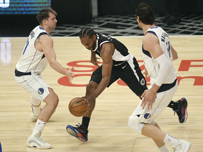 Kawhi Leonard is guarded by Luka Doncic and Boban Marjanovic