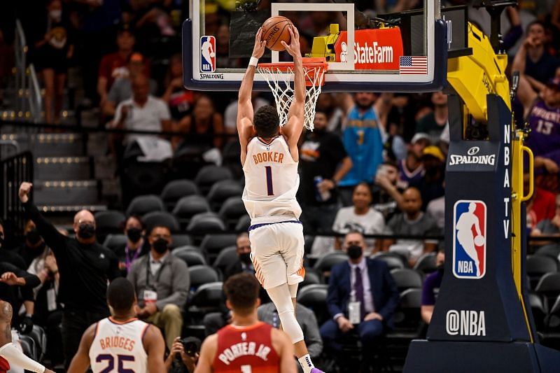 Devin Booker #1 of the Phoenix Suns scores on a slam dunk