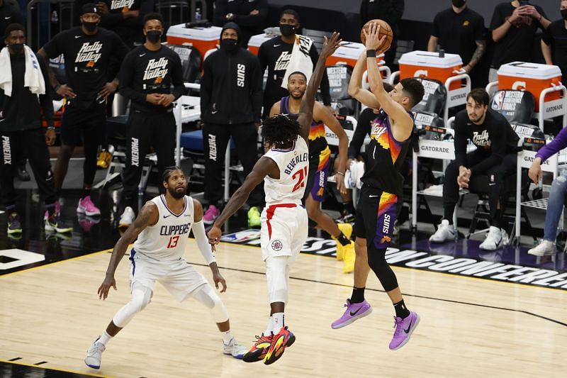 Devin Booker #1 puts up a basket ahead of Patrick Beverley #21