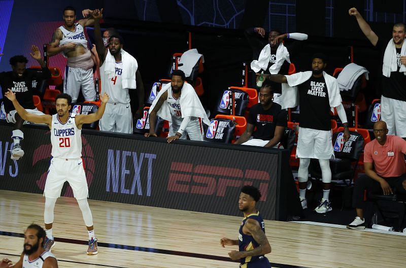 Members of the LA Clippers cheer for their teammates from the bench