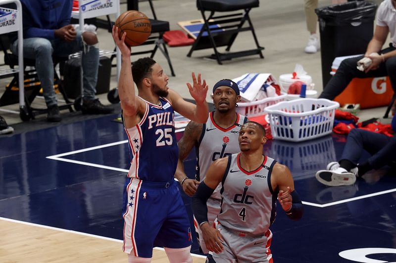 Ben Simmons #25 puts up a shot over Bradley Beal #3 and Russell Westbrook #4