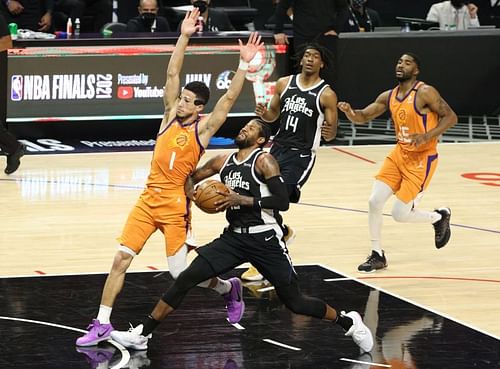 Paul George #13 drives to the basket against Devin Booker #1