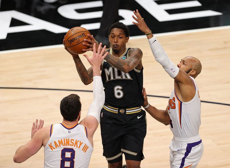 Lou Williams #6 of the Atlanta Hawks battles against two players from the 76ers