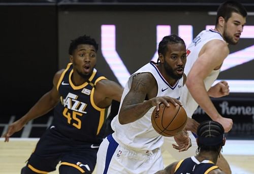 Kawhi Leonard dribbles away from Donovan Mitchell